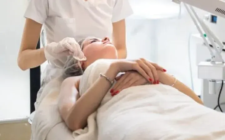 Paciente tumbada en cabina durante un tratamiento facial